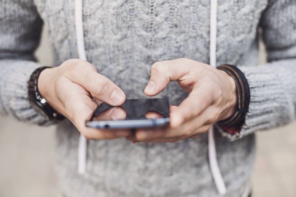 garçon tenant un téléphone dans la main